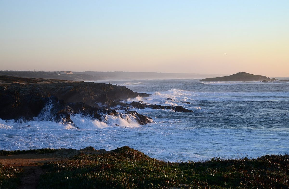 The coast of Porto Covo in soft light, with the Pessegueiro Island on the horizon
