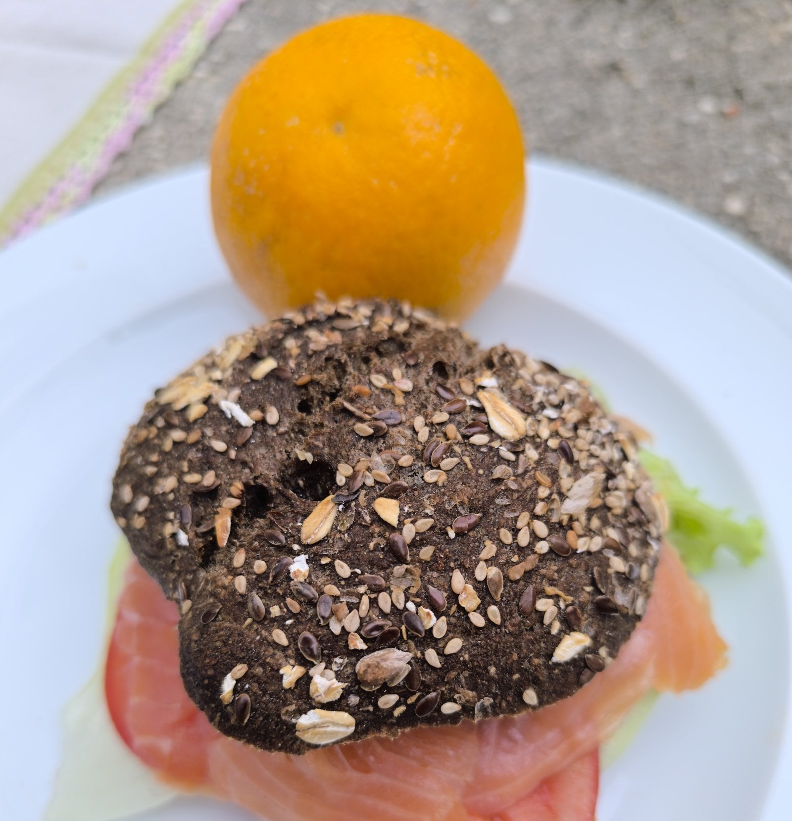 Traking Transfers Salmon Sandwich on dark seeded bread, served with fresh fruit on the plate