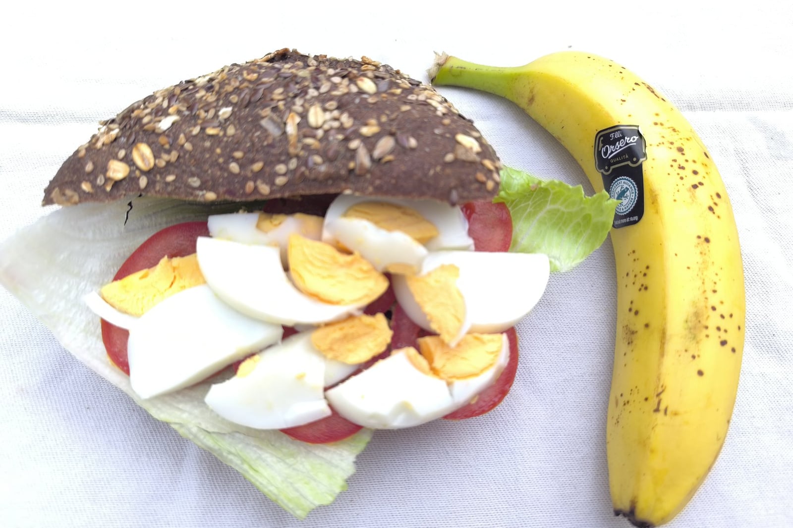 Traking Transfers Vegetarian Sandwich Pack with boiled egg on dark seeded bread, banana beside it